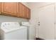 Functional laundry room with overhead cabinets and white washer and dryer units at 1022 N Kirby St, Gilbert, AZ 85234