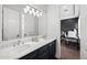 Bathroom with double vanity, large mirror, modern lighting, and a view of the bedroom at 10448 E Glencove St, Mesa, AZ 85207