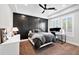 Modern bedroom features a tray ceiling, black accent wall, two windows, a ceiling fan and carpeted floors at 10448 E Glencove St, Mesa, AZ 85207