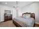 Comfortable bedroom with a plush patterned bed, wooden dresser, and ceiling fan at 10448 E Glencove St, Mesa, AZ 85207