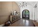 Elegant foyer featuring decorative cabinet, arched doorway, chandelier, and decorative iron entry doors at 10448 E Glencove St, Mesa, AZ 85207