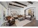 Spacious living room with an oversized leather sofa, exposed wood beams, and open floor plan at 10448 E Glencove St, Mesa, AZ 85207