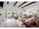 Spacious living room with wood beams, an oversized leather sofa, and sliding glass doors to patio at 10448 E Glencove St, Mesa, AZ 85207