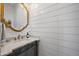 Stylish powder room featuring a designer mirror, shiplap walls, and a marble countertop at 10448 E Glencove St, Mesa, AZ 85207