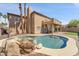 Stunning backyard with a pool, rock features, and a covered patio, ideal for outdoor enjoyment at 10997 E Altadena Ave, Scottsdale, AZ 85259