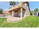 Inviting backyard features a covered patio, lush lawn, brick pavers, a refreshing pool, and a second-story balcony at 10997 E Altadena Ave, Scottsdale, AZ 85259