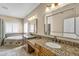 Elegant bathroom featuring dual sinks, granite countertops, and a luxurious soaking tub at 10997 E Altadena Ave, Scottsdale, AZ 85259