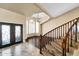 Grand foyer features a staircase with wood railings, decorative front doors and ample natural light at 10997 E Altadena Ave, Scottsdale, AZ 85259