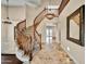 A grand foyer features a sweeping staircase with wood banister and marble tile flooring at 10997 E Altadena Ave, Scottsdale, AZ 85259
