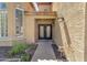 Home entrance with wrought iron double doors, small garden, and stone pathway at 10997 E Altadena Ave, Scottsdale, AZ 85259