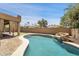 Beautiful pool with a rock feature and lush landscaping, perfect for outdoor relaxation and entertainment at 10997 E Altadena Ave, Scottsdale, AZ 85259