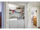 Bright, organized laundry room with washer, dryer, shelves, and natural light at 11144 N 109Th Way, Scottsdale, AZ 85259