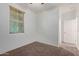 View of a bedroom with a window with blinds and neutral colored carpet at 11952 W Overlin Ln, Avondale, AZ 85323