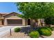 Inviting single-story home featuring a charming front yard with mature tree and desert landscaping at 11952 W Overlin Ln, Avondale, AZ 85323