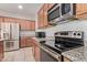 Well-lit kitchen featuring stainless steel appliances, tile flooring, and granite countertops at 11952 W Overlin Ln, Avondale, AZ 85323
