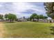 Expansive backyard with lush green lawn, mature trees, and a detached garage at 12548 E Cloud Rd, Chandler, AZ 85249