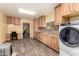 Spacious laundry room with wood cabinets, an office desk, and matching wood-look floors at 12548 E Cloud Rd, Chandler, AZ 85249