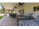Covered patio area with ceiling fans, an outdoor kitchen, and comfortable lounge furniture at 12548 E Cloud Rd, Chandler, AZ 85249