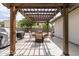 This pergola has an outdoor dining area, lighting, and a view of the yard at 12548 E Cloud Rd, Chandler, AZ 85249