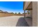 Large backyard with a gravel yard, covered patio, block wall, and neighborhood views under a bright blue sky at 1268 E Jahns Dr, Casa Grande, AZ 85122