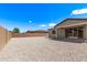 Spacious backyard with gravel, block wall, covered patio area, and neighborhood views on a sunny day at 1268 E Jahns Dr, Casa Grande, AZ 85122