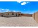 Wide view of gravel backyard with covered patio, block wall, sunny sky above the home at 1268 E Jahns Dr, Casa Grande, AZ 85122