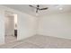 A serene bedroom with neutral carpet, a ceiling fan, and a doorway to an ensuite bathroom at 1268 E Jahns Dr, Casa Grande, AZ 85122