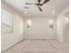 A bright bedroom boasts neutral carpet, a ceiling fan, and large windows for ample natural light at 1268 E Jahns Dr, Casa Grande, AZ 85122