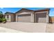 Tan home featuring a two-car garage, beautiful landscaping, and a brick driveway at 1268 E Jahns Dr, Casa Grande, AZ 85122