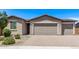 Tan home featuring a two-car garage, beautiful landscaping, and a brick driveway at 1268 E Jahns Dr, Casa Grande, AZ 85122