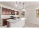 A well-lit kitchen includes an island with a sink, stainless steel appliances, and an open window at 1268 E Jahns Dr, Casa Grande, AZ 85122