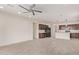 Open floor plan of living room leading to kitchen featuring luxury vinyl plank flooring and a ceiling fan at 1268 E Jahns Dr, Casa Grande, AZ 85122