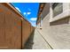 Narrow side yard featuring gravel, tan block wall, and proximity to the house with window views against a blue sky at 1268 E Jahns Dr, Casa Grande, AZ 85122