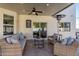 Covered patio featuring outdoor seating, ceiling fan, wall decor, and travertine tile at 1349 N Lakeshore Dr, Chandler, AZ 85226
