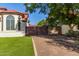 Exterior view showcasing the home's architecture, gated entrance, and lush landscaping at 1349 N Lakeshore Dr, Chandler, AZ 85226