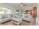 Bright living room featuring neutral furnishings, a ceiling fan, and a view into the connected kitchen at 1349 N Lakeshore Dr, Chandler, AZ 85226