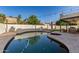 Backyard featuring a custom pool, hot tub, covered patio, artificial lawn, and privacy wall at 1349 N Lakeshore Dr, Chandler, AZ 85226