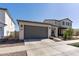 Beige two-story home featuring a two-car garage, neutral landscaping, and a concrete driveway at 14601 W Valentine St, Surprise, AZ 85379