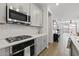 Updated kitchen showcases stainless steel appliances, sleek gray cabinets and quartz counters at 14601 W Valentine St, Surprise, AZ 85379