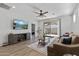 Comfortable living room with TV and ceiling fan extends through sliding doors to outdoor patio at 14601 W Valentine St, Surprise, AZ 85379