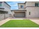 Wide backyard showing artificial turf, gravel landscaping, and a covered patio with sliding glass doors at 16010 N 74Th Ln, Peoria, AZ 85382