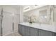 Bathroom featuring a double vanity, gray cabinets, and a glass-enclosed shower at 16010 N 74Th Ln, Peoria, AZ 85382