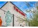 The building has a distressed white brick exterior with a green skull mural and bold red signage at 16010 N 74Th Ln, Peoria, AZ 85382