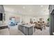 Open kitchen and living area with a central island, stainless steel appliances, and a sliding door to the outdoor patio at 16010 N 74Th Ln, Peoria, AZ 85382