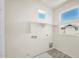 Bright laundry room with a utility sink, wooden-look flooring, a shelf, and multiple windows at 16010 N 74Th Ln, Peoria, AZ 85382