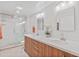 Modern bathroom featuring a double vanity, sleek hardware, and a frameless glass shower enclosure at 17890 N 99Th Dr, Sun City, AZ 85373