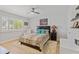 Cozy bedroom with a ceiling fan, shuttered window, hardwood floors, and stylish decor at 17890 N 99Th Dr, Sun City, AZ 85373