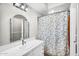 Bright bathroom featuring white countertops, an arch mirror, and a shower with a blue floral curtain at 18822 E Flintlock Dr, Queen Creek, AZ 85142