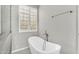 Spa-like bathroom with modern tub, fixtures, and a shuttered glass block window at 18822 E Flintlock Dr, Queen Creek, AZ 85142