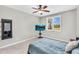 Modern bedroom with shuttered window, ceiling fan, and wall-mounted TV at 18822 E Flintlock Dr, Queen Creek, AZ 85142